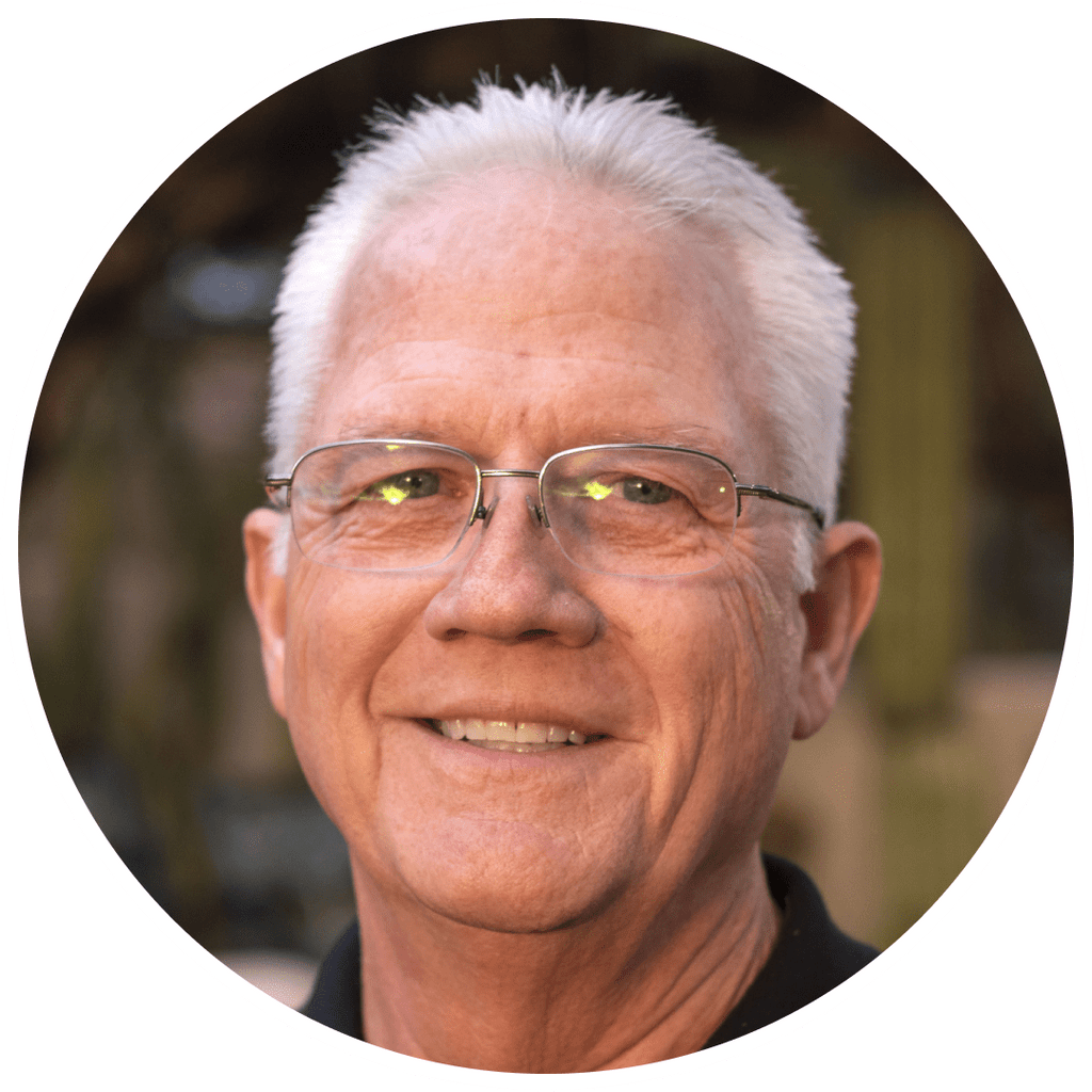 Smiling man with glasses in a circular frame.