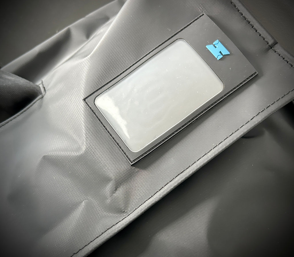 Close-up of a black bag with a clear ID window.