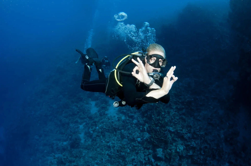 Scuba diver giving OK sign underwater, regulator serviced