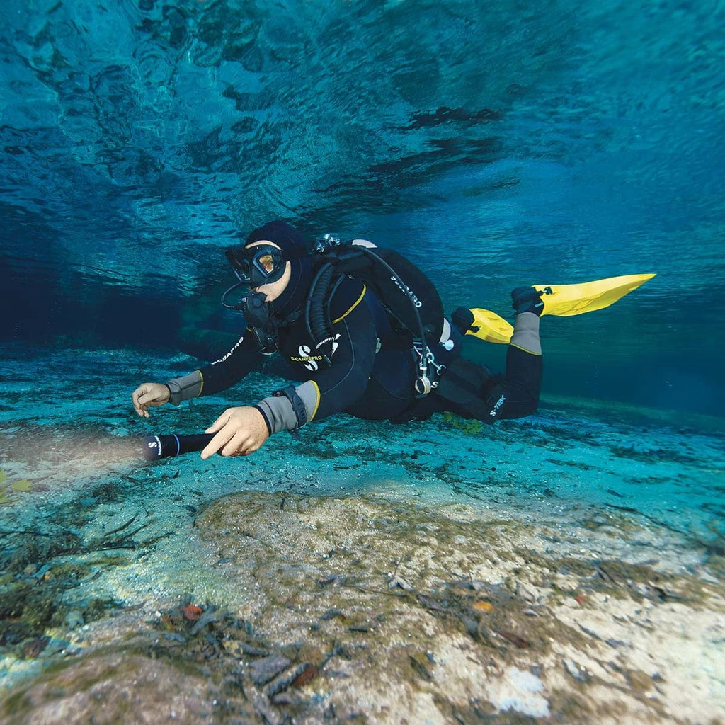 Scuba diver exploring underwater with a light.